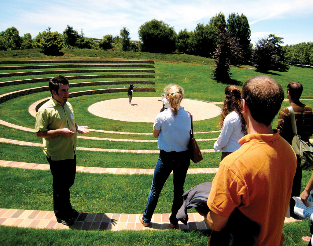 Photo of tour guide and group at outdoor amphitheater